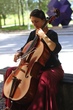 Leonor Palazzo playing the cello on a bench